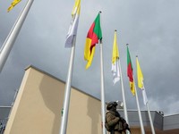 A soldier stands guard next to fluttering Cameroonian and Vatican flags at Yaounde Nsimalen International Airport, ahead of Pope Leo XIV's departure for Bamenda, where he will attend a meeting for peace and hold a holy Mass, in Yaounde, Cameroon, Apr