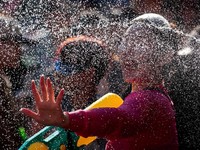Seorang pengunjung bermain air saat orang-orang merayakan liburan Songkran, yang menandai Tahun Baru Thailand, di Khao San Road, salah satu tempat wisata favorit di Bangkok, Thailand, 13 April 2026. (REUTERS/Patipat Janthong)