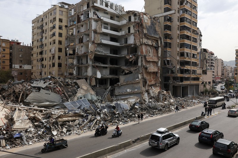 People gather at the site of an Israeli strike carried out before a 10-day ceasefire between Lebanon and Israel went into effect, in Tyre, Lebanon, April 17, 2026. REUTERS/Louisa Gouliamaki
