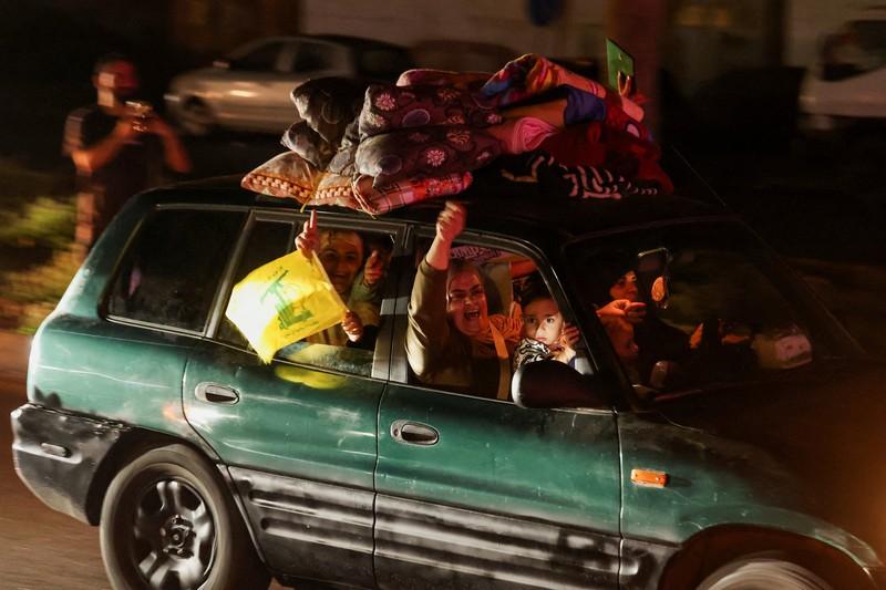 Para pengungsi bereaksi saat mereka kembali ke rumah mereka dengan kendaraan yang membawa barang-barang di atapnya setelah gencatan senjata 10 hari antara Lebanon dan Israel mulai berlaku, di Sidon, Lebanon, 17 April 2026. (REUTERS/Aziz Taher)