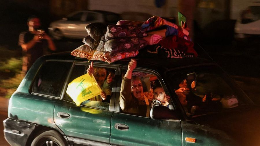 Para pengungsi bereaksi saat mereka kembali ke rumah mereka dengan kendaraan yang membawa barang-barang di atapnya setelah gencatan senjata 10 hari antara Lebanon dan Israel mulai berlaku, di Sidon, Lebanon, 17 April 2026. (REUTERS/Aziz Taher)