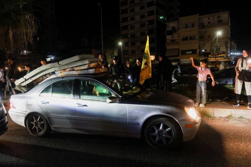 Para pengungsi bereaksi saat mereka kembali ke rumah mereka dengan kendaraan yang membawa barang-barang di atapnya setelah gencatan senjata 10 hari antara Lebanon dan Israel mulai berlaku, di Sidon, Lebanon, 17 April 2026. (REUTERS/Aziz Taher)