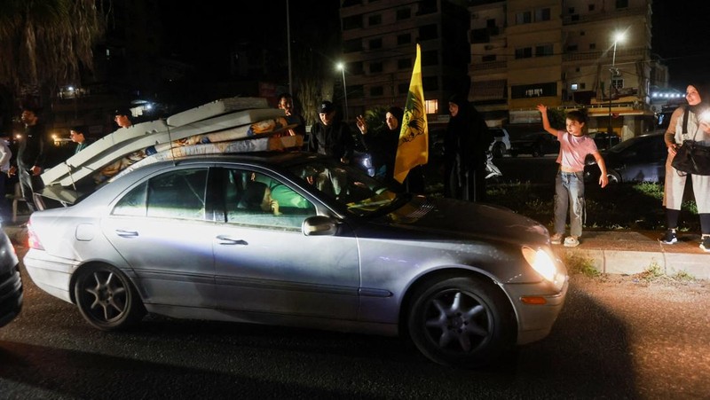 Para pengungsi bereaksi saat mereka kembali ke rumah mereka dengan kendaraan yang membawa barang-barang di atapnya setelah gencatan senjata 10 hari antara Lebanon dan Israel mulai berlaku, di Sidon, Lebanon, 17 April 2026. (REUTERS/Aziz Taher)