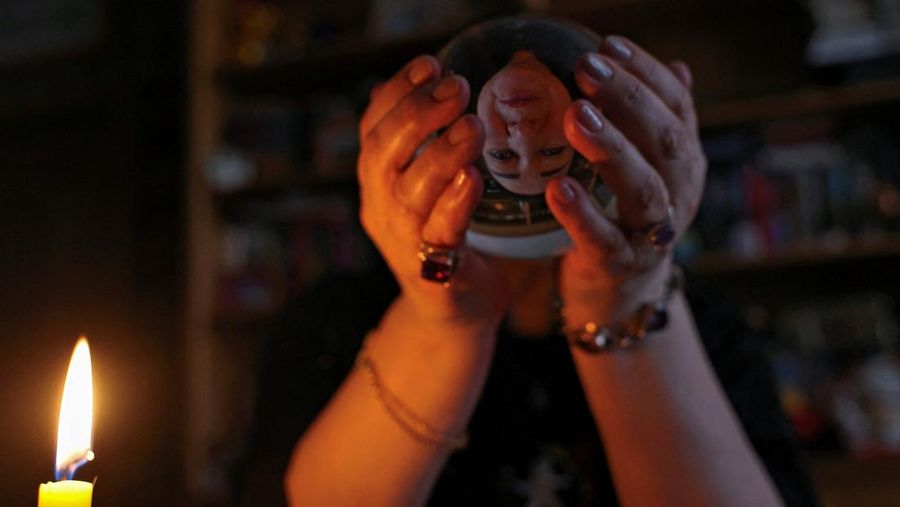 Fortune teller Arina Frants lays out Tarot cards on a table in the voodoo-themed bar Marie Laveau in Moscow, Russia February 17, 2026. REUTERS/Shamil Zhumatov