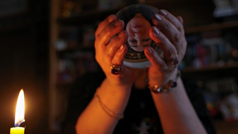 Fortune teller Arina Frants lays out Tarot cards on a table in the voodoo-themed bar Marie Laveau in Moscow, Russia February 17, 2026. REUTERS/Shamil Zhumatov
