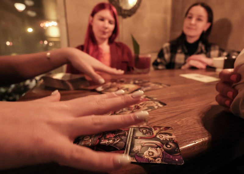 Fortune teller Arina Frants lays out Tarot cards on a table in the voodoo-themed bar Marie Laveau in Moscow, Russia February 17, 2026. REUTERS/Shamil Zhumatov