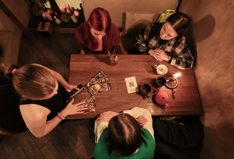 Fortune teller Arina Frants lays out Tarot cards on a table in the voodoo-themed bar Marie Laveau in Moscow, Russia February 17, 2026. REUTERS/Shamil Zhumatov