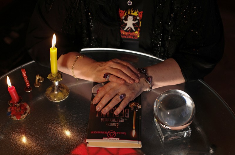 Fortune teller Arina Frants lays out Tarot cards on a table in the voodoo-themed bar Marie Laveau in Moscow, Russia February 17, 2026. REUTERS/Shamil Zhumatov
