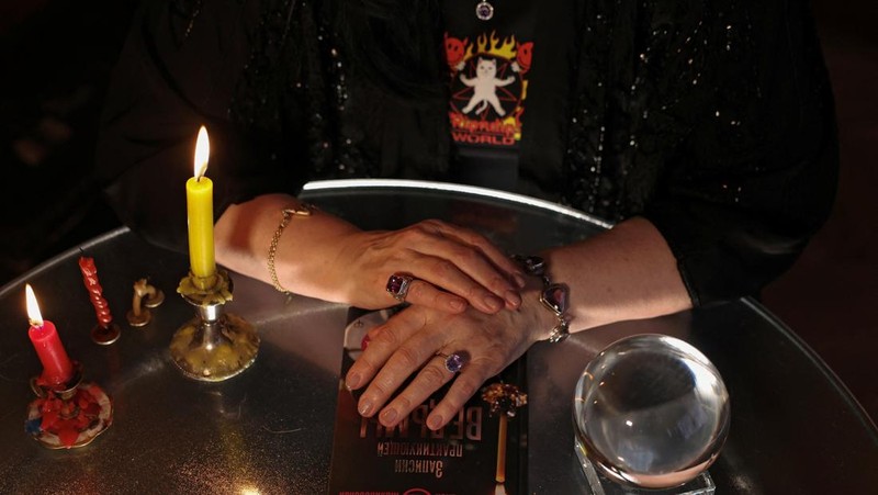Fortune teller Arina Frants lays out Tarot cards on a table in the voodoo-themed bar Marie Laveau in Moscow, Russia February 17, 2026. REUTERS/Shamil Zhumatov