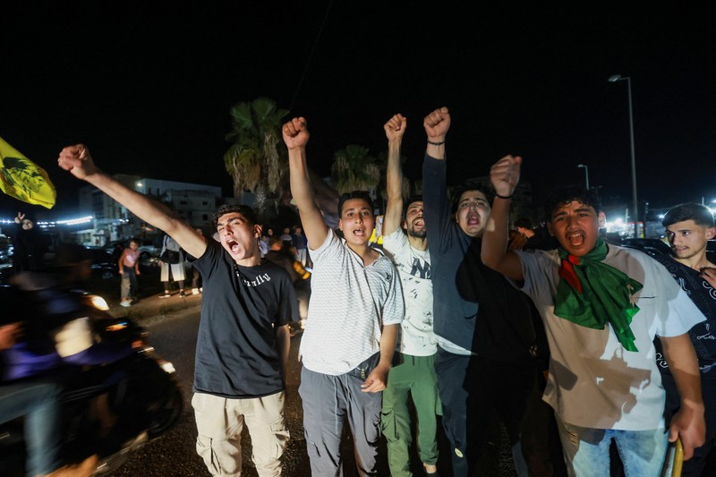 Para pengungsi bereaksi saat mereka kembali ke rumah mereka dengan kendaraan yang membawa barang-barang di atapnya setelah gencatan senjata 10 hari antara Lebanon dan Israel mulai berlaku, di Sidon, Lebanon, 17 April 2026. (REUTERS/Aziz Taher)