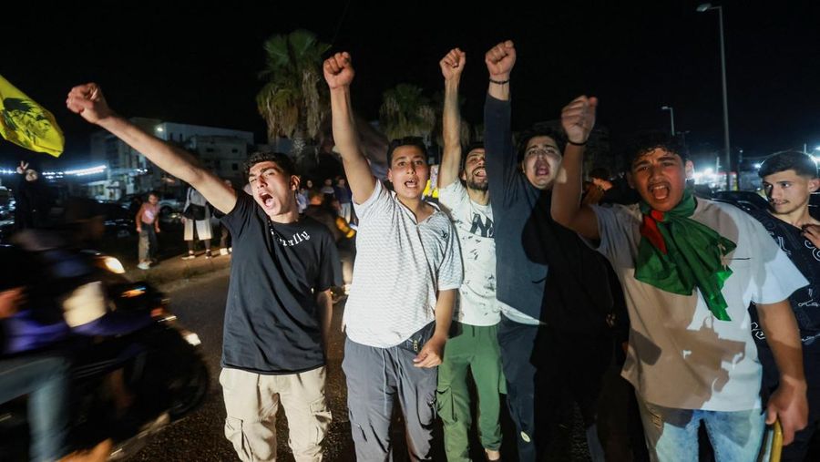 Para pengungsi bereaksi saat mereka kembali ke rumah mereka dengan kendaraan yang membawa barang-barang di atapnya setelah gencatan senjata 10 hari antara Lebanon dan Israel mulai berlaku, di Sidon, Lebanon, 17 April 2026. (REUTERS/Aziz Taher)