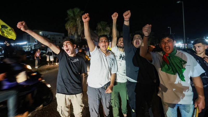 Para pengungsi bereaksi saat mereka kembali ke rumah mereka dengan kendaraan yang membawa barang-barang di atapnya setelah gencatan senjata 10 hari antara Lebanon dan Israel mulai berlaku, di Sidon, Lebanon, 17 April 2026. (REUTERS/Aziz Taher)