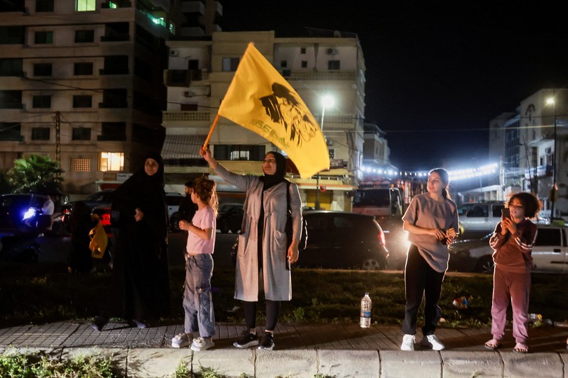 Para pengungsi bereaksi saat mereka kembali ke rumah mereka dengan kendaraan yang membawa barang-barang di atapnya setelah gencatan senjata 10 hari antara Lebanon dan Israel mulai berlaku, di Sidon, Lebanon, 17 April 2026. (REUTERS/Aziz Taher)