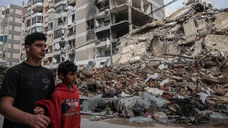 Orang-orang berjalan melewati bangunan yang hancur, setelah gencatan senjata selama 10 hari antara Lebanon dan Israel mulai berlaku, di pinggiran selatan Beirut, Lebanon, 18 April 2026. (REUTERS/Marko Djurica)
