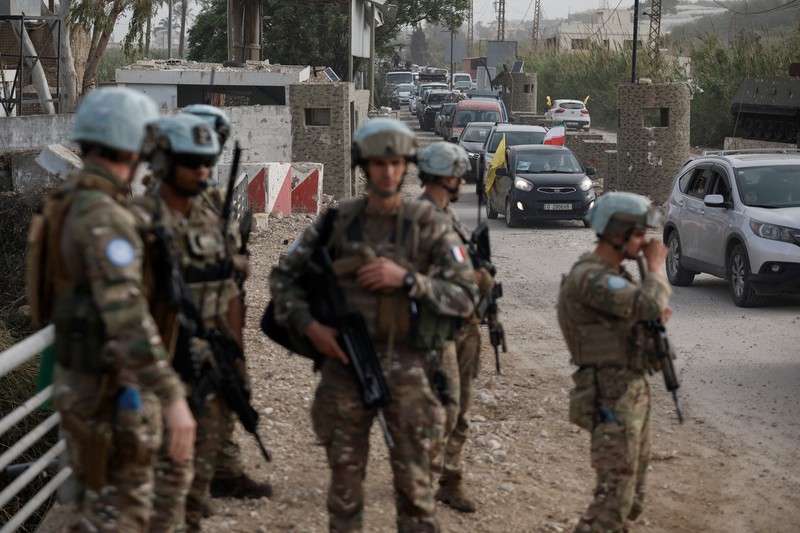 Pasukan penjaga perdamaian PBB berjaga-jaga saat para pengungsi kembali ke rumah mereka menyeberangi jembatan yang menghubungkan Lebanon selatan dengan bagian negara lainnya, yang sebelumnya dihantam serangan Israel, setelah gencatan senjata 10 hari antara Lebanon dan Israel mulai berlaku, di Qasmiyeh, Lebanon, 18 April 2026. (REUTERS/Louisa Gouliamaki)