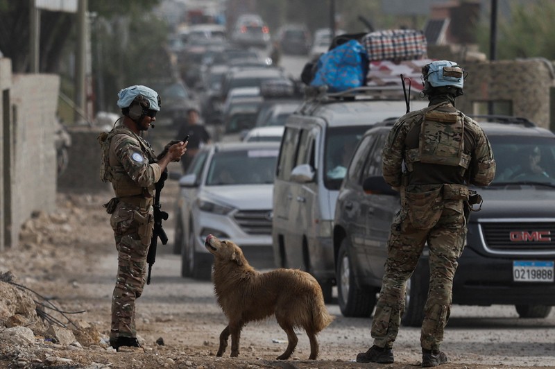 Pasukan penjaga perdamaian PBB berjaga-jaga saat para pengungsi kembali ke rumah mereka menyeberangi jembatan yang menghubungkan Lebanon selatan dengan bagian negara lainnya, yang sebelumnya dihantam serangan Israel, setelah gencatan senjata 10 hari antara Lebanon dan Israel mulai berlaku, di Qasmiyeh, Lebanon, 18 April 2026. (REUTERS/Louisa Gouliamaki)