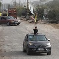 Seorang anak laki-laki melambaikan bendera dari dalam kendaraan saat para pengungsi kembali ke rumah mereka menyeberangi jembatan yang menghubungkan Lebanon selatan dengan bagian negara lainnya, yang sebelumnya dihantam serangan Israel, setelah genca