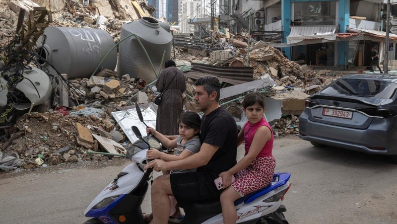 Pasukan penjaga perdamaian PBB berjaga-jaga saat para pengungsi kembali ke rumah mereka menyeberangi jembatan yang menghubungkan Lebanon selatan dengan bagian negara lainnya, yang sebelumnya dihantam serangan Israel, setelah gencatan senjata 10 hari antara Lebanon dan Israel mulai berlaku, di Qasmiyeh, Lebanon, 18 April 2026. (REUTERS/Louisa Gouliamaki)