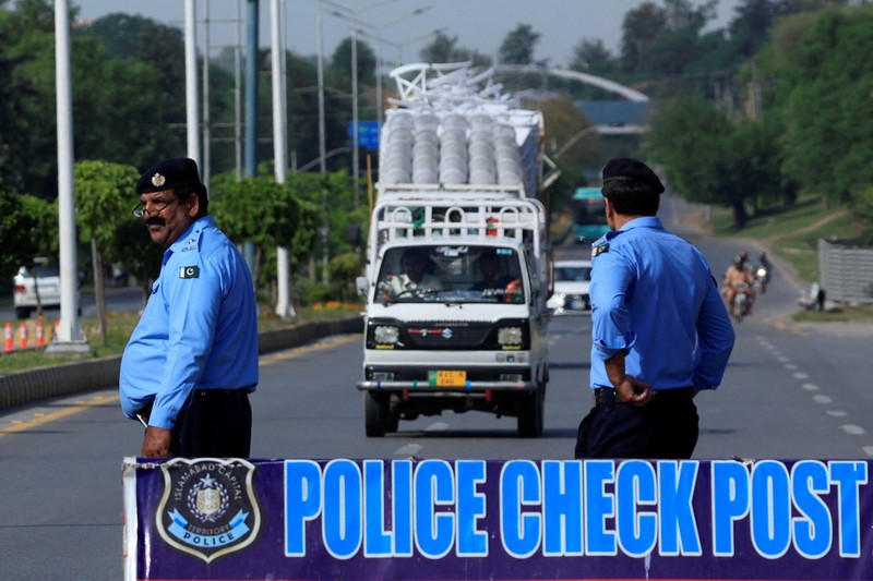 Seorang petugas polisi memberi isyarat ke sebuah kendaraan di pos pemeriksaan di sepanjang jalan dekat Masjid Faisal, saat Pakistan bersiap menjadi tuan rumah bagi AS dan Iran untuk fase kedua pembicaraan perdamaian di Islamabad, Pakistan, 19 April 2026. (REUTERS/Akhtar Soomro)