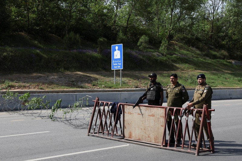 Seorang petugas polisi memberi isyarat ke sebuah kendaraan di pos pemeriksaan di sepanjang jalan dekat Masjid Faisal, saat Pakistan bersiap menjadi tuan rumah bagi AS dan Iran untuk fase kedua pembicaraan perdamaian di Islamabad, Pakistan, 19 April 2026. (REUTERS/Akhtar Soomro)