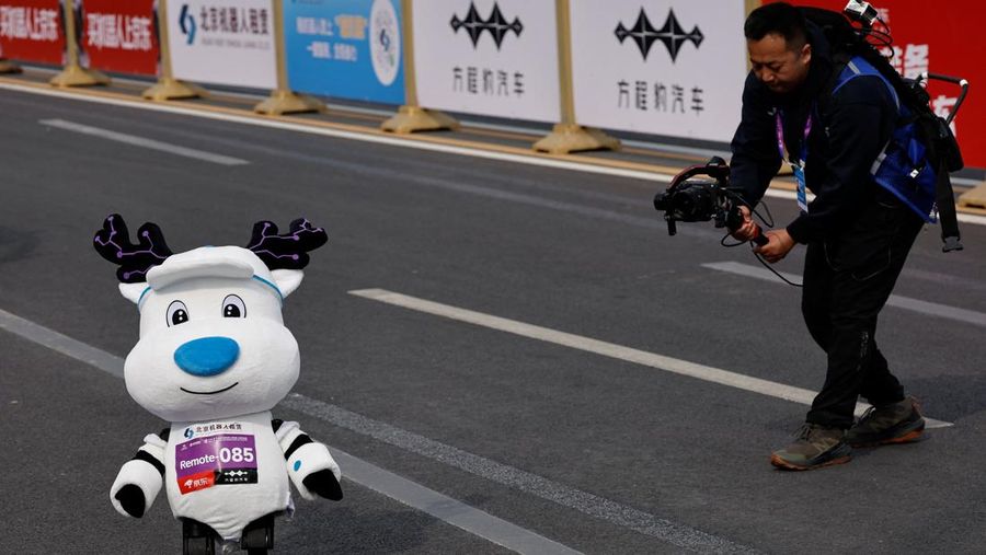 Robot humanoid Mini Pi+ buatan Gaoqing Electromechanical, mengenakan kostum, ikut serta dalam ajang Beijing E-Town Half Marathon dan Humanoid Robot Half Marathon kedua di Beijing, Tiongkok pada 19 April 2026.