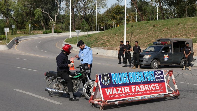 Seorang petugas polisi memberi isyarat ke sebuah kendaraan di pos pemeriksaan di sepanjang jalan dekat Masjid Faisal, saat Pakistan bersiap menjadi tuan rumah bagi AS dan Iran untuk fase kedua pembicaraan perdamaian di Islamabad, Pakistan, 19 April 2026. (REUTERS/Akhtar Soomro)