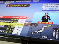 Layar televisi menampilkan laporan berita tentang peringatan tsunami dari Badan Meteorologi Jepang, yang menyatakan bahwa gelombang tsunami setinggi hingga 3 meter (9,84 kaki) diperkirakan akan mencapai wilayah pesisir besar di Jepang utara setelah g