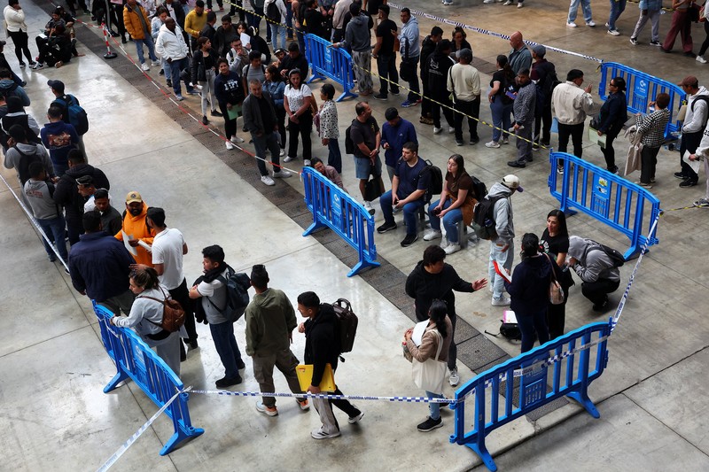 Orang-orang mengantre untuk menerima dokumen saat proses regularisasi migran massal Spanyol akan dimulai, di Hospitalet de Llobregat, dekat Barcelona, ​​Spanyol, 20 April 2026. REUTERS/Albert Gea