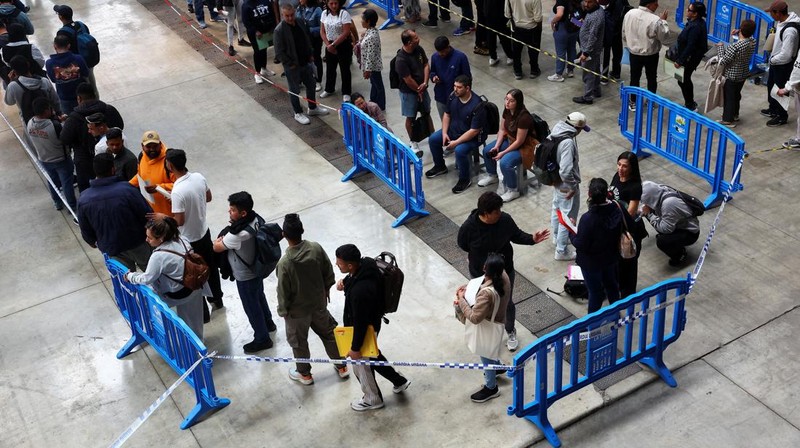 Orang-orang mengantre untuk menerima dokumen saat proses regularisasi migran massal Spanyol akan dimulai, di Hospitalet de Llobregat, dekat Barcelona, ​​Spanyol, 20 April 2026. REUTERS/Albert Gea