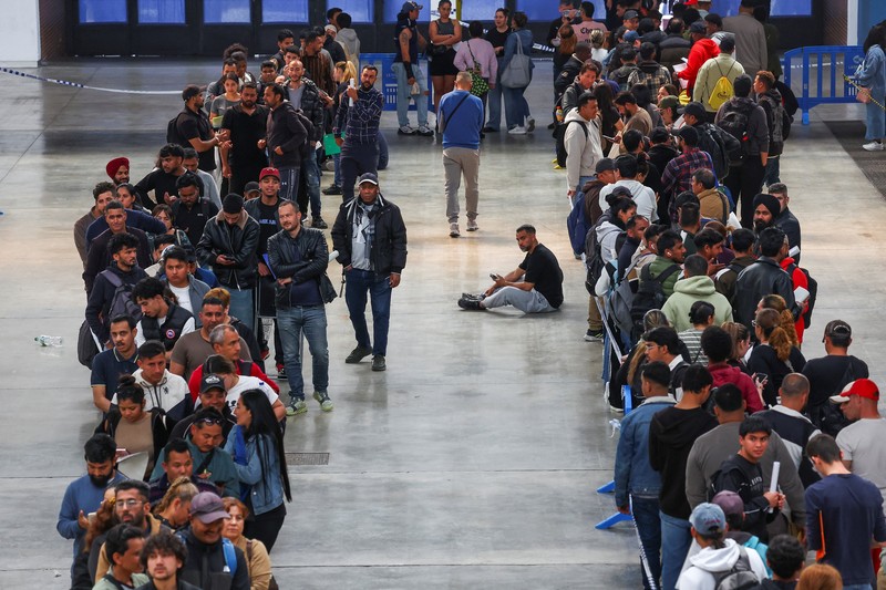 Orang-orang mengantre untuk menerima dokumen saat proses regularisasi migran massal Spanyol akan dimulai, di Hospitalet de Llobregat, dekat Barcelona, ​​Spanyol, 20 April 2026. REUTERS/Albert Gea