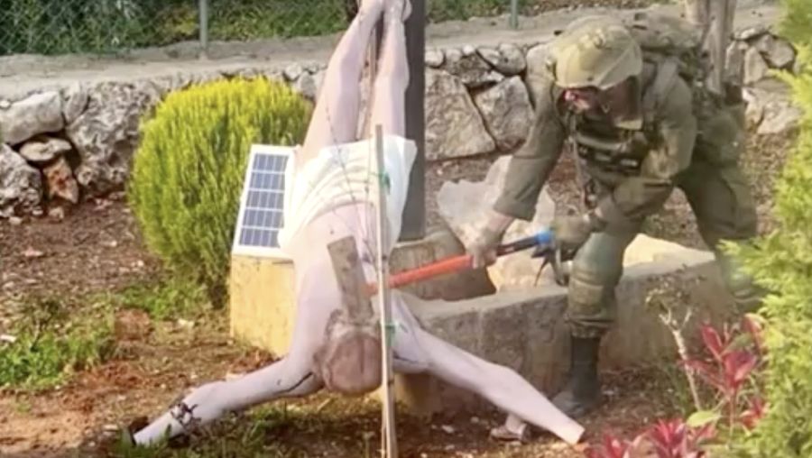Seorang tentara menghancurkan patung Yesus di Lebanon selatan.