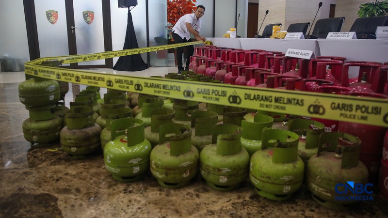 Petugas memasang garis polisi pada barang bukti saat konferensi pers Pengungkapan Kasus Penyalahgunaan BBM dan Elipiji Subsidi di Bareskrim Polri, Jakarta, Selasa (21/4/2026). (CNBC Indonesia/Faisal Rahman)