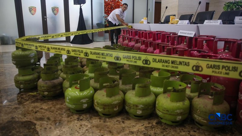 Petugas memasang garis polisi pada barang bukti saat konferensi pers Pengungkapan Kasus Penyalahgunaan BBM dan Elipiji Subsidi di Bareskrim Polri, Jakarta, Selasa (21/4/2026). (CNBC Indonesia/Faisal Rahman)