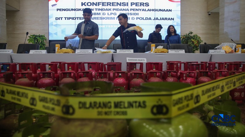 Petugas memasang garis polisi pada barang bukti saat konferensi pers Pengungkapan Kasus Penyalahgunaan BBM dan Elipiji Subsidi di Bareskrim Polri, Jakarta, Selasa (21/4/2026). (CNBC Indonesia/Faisal Rahman)