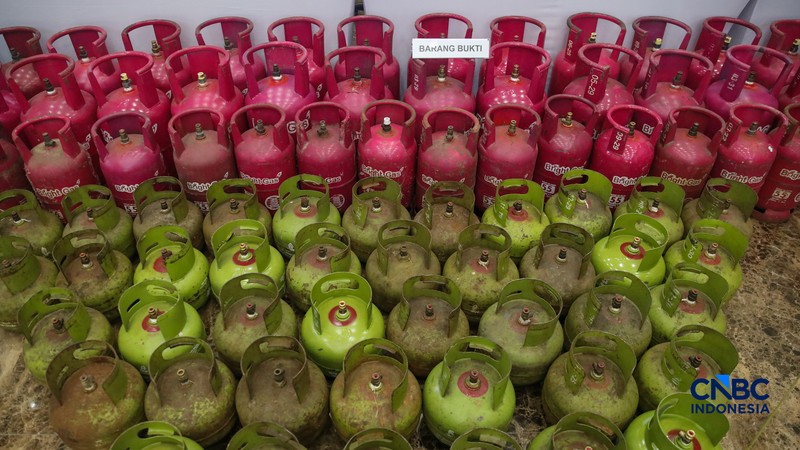 Petugas memasang garis polisi pada barang bukti saat konferensi pers Pengungkapan Kasus Penyalahgunaan BBM dan Elipiji Subsidi di Bareskrim Polri, Jakarta, Selasa (21/4/2026). (CNBC Indonesia/Faisal Rahman)