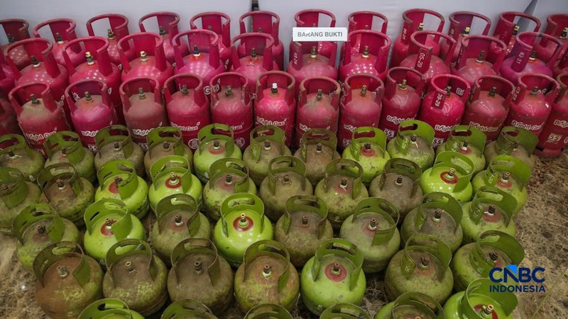 Petugas memasang garis polisi pada barang bukti saat konferensi pers Pengungkapan Kasus Penyalahgunaan BBM dan Elipiji Subsidi di Bareskrim Polri, Jakarta, Selasa (21/4/2026). (CNBC Indonesia/Faisal Rahman)