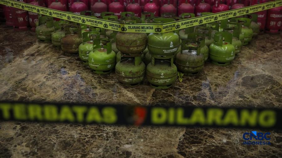 Petugas memasang garis polisi pada barang bukti saat konferensi pers Pengungkapan Kasus Penyalahgunaan BBM dan Elipiji Subsidi di Bareskrim Polri, Jakarta, Selasa (21/4/2026). (CNBC Indonesia/Faisal Rahman)