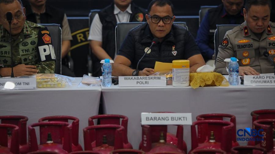 Petugas memasang garis polisi pada barang bukti saat konferensi pers Pengungkapan Kasus Penyalahgunaan BBM dan Elipiji Subsidi di Bareskrim Polri, Jakarta, Selasa (21/4/2026). (CNBC Indonesia/Faisal Rahman)
