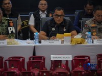 Petugas memasang garis polisi pada barang bukti saat konferensi pers Pengungkapan Kasus Penyalahgunaan BBM dan Elipiji Subsidi di Bareskrim Polri, Jakarta, Selasa (21/4/2026). (CNBC Indonesia/Faisal Rahman)