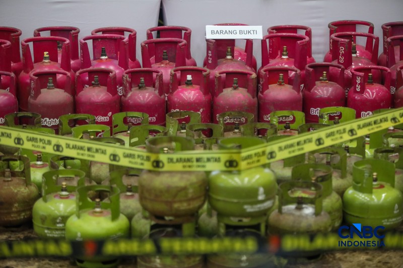 Petugas memasang garis polisi pada barang bukti saat konferensi pers Pengungkapan Kasus Penyalahgunaan BBM dan Elipiji Subsidi di Bareskrim Polri, Jakarta, Selasa (21/4/2026). (CNBC Indonesia/Faisal Rahman)