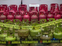 Petugas memasang garis polisi pada barang bukti saat konferensi pers Pengungkapan Kasus Penyalahgunaan BBM dan Elipiji Subsidi di Bareskrim Polri, Jakarta, Selasa (21/4/2026). (CNBC Indonesia/Faisal Rahman)