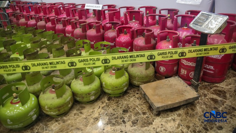 Petugas memasang garis polisi pada barang bukti saat konferensi pers Pengungkapan Kasus Penyalahgunaan BBM dan Elipiji Subsidi di Bareskrim Polri, Jakarta, Selasa (21/4/2026). (CNBC Indonesia/Faisal Rahman)