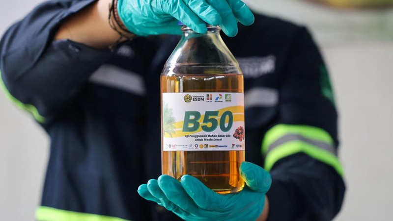 Seorang teknisi laboratorium berpose untuk foto sambil memegang sebotol bahan bakar biodiesel sawit 50% selama acara pengujian B50, seiring Indonesia berencana untuk menaikkan tingkat pencampuran wajib untuk biodiesel berbasis sawit dari 40% menjadi