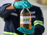 Seorang teknisi laboratorium berpose untuk foto sambil memegang sebotol bahan bakar biodiesel sawit 50% selama acara pengujian B50, seiring Indonesia berencana untuk menaikkan tingkat pencampuran wajib untuk biodiesel berbasis sawit dari 40% menjadi
