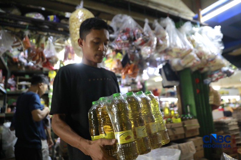 Pekerja menuang minyak curah ke dalam plastik kiloan di kawasan Pasar Pondok Labu, Jakarta Selatan, Rabu, (22/4/2026). (CNBC Indonesia/Muhammad Sabki)