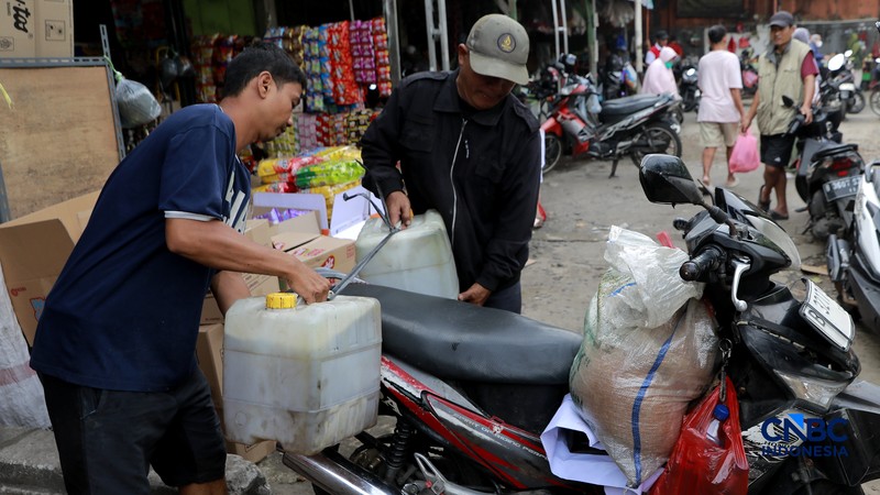 Pekerja menuang minyak curah ke dalam plastik kiloan di kawasan Pasar Pondok Labu, Jakarta Selatan, Rabu, (22/4/2026). (CNBC Indonesia/Muhammad Sabki)