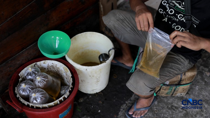 Pekerja menuang minyak curah ke dalam plastik kiloan di kawasan Pasar Pondok Labu, Jakarta Selatan, Rabu, (22/4/2026). (CNBC Indonesia/Muhammad Sabki)