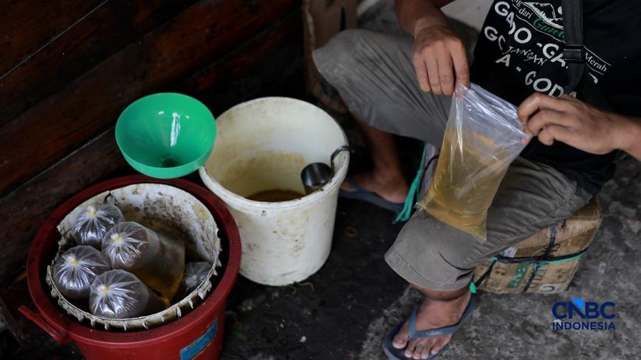 Pekerja menuang minyak curah ke dalam plastik kiloan di kawasan Pasar Pondok Labu, Jakarta Selatan, Rabu, (22/4/2026).