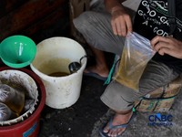 Foto: Pekerja menuang minyak curah ke dalam plastik kiloan di Pasar Pondok Labu, Jakarta Selatan, Rabu (22/4/2026). (CNBC Indonesia/Muhammad Sabki)