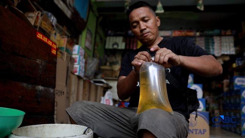 Pekerja menuang minyak curah ke dalam plastik kiloan di kawasan Pasar Pondok Labu, Jakarta Selatan, Rabu, (22/4/2026). (CNBC Indonesia/Muhammad Sabki)